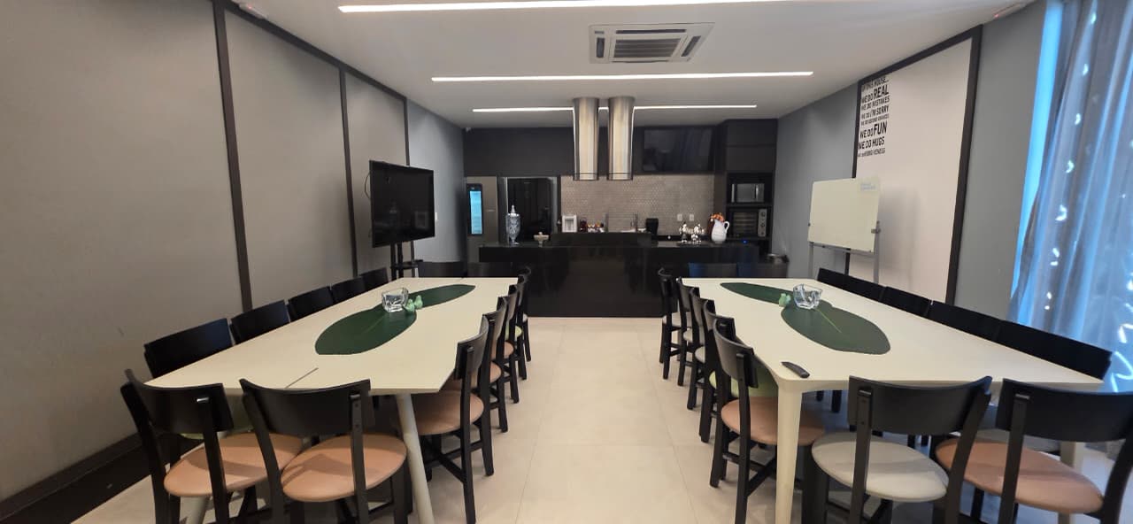 Sala do Espaço Contemporânea com mesas, televisão, quadro branco e bancada ao fundo